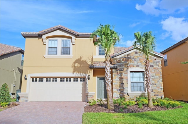 view of front of house featuring stone siding, a tile roof, decorative driveway, stucco siding, and an attached garage