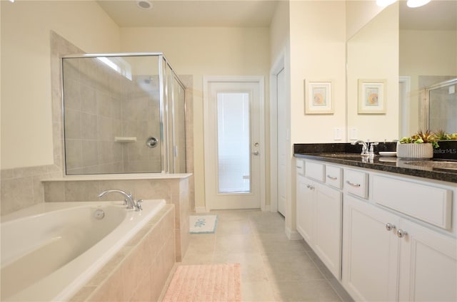 full bath featuring a shower stall, a garden tub, vanity, and tile patterned floors