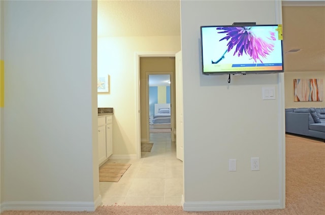 corridor featuring baseboards and light tile patterned flooring