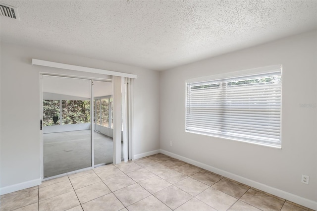 1051 Arden St, Longwood, FL 32750 - empty room featuring visible vents, a textured ceiling, light tile patterned floors, and baseboards