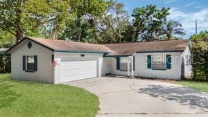 1051 Arden St, Longwood, FL 32750 - ranch-style home with a garage, a front lawn, stucco siding, and driveway