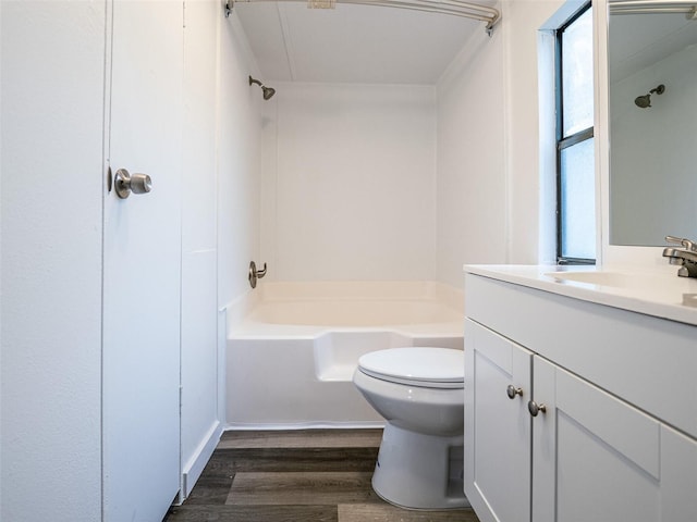 bathroom featuring vanity, wood finished floors, toilet, and tub / shower combination