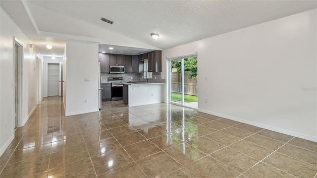 kitchen featuring appliances with stainless steel finishes, visible vents, light countertops, light tile patterned flooring, and open floor plan