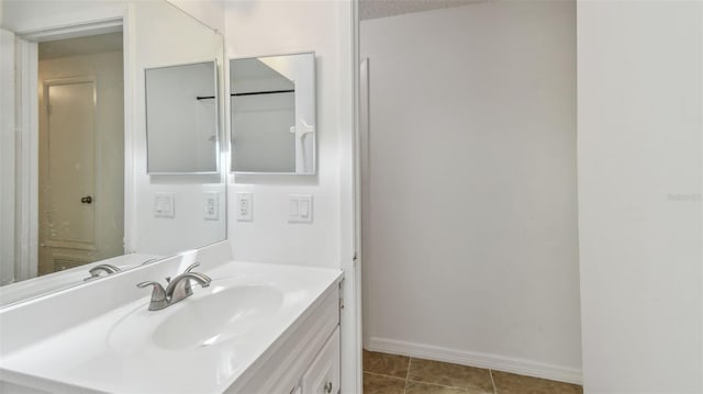bathroom with baseboards, tile patterned flooring, and vanity