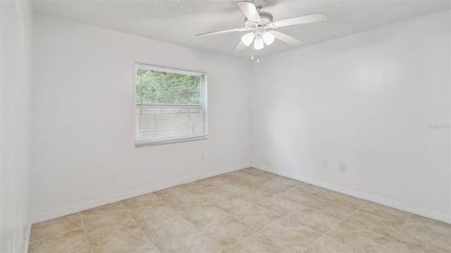 unfurnished room with a textured ceiling, ceiling fan, and baseboards