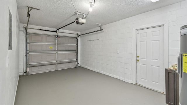 garage with concrete block wall and a garage door opener