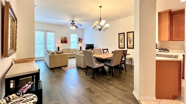 dining room with wood finished floors and ceiling fan with notable chandelier