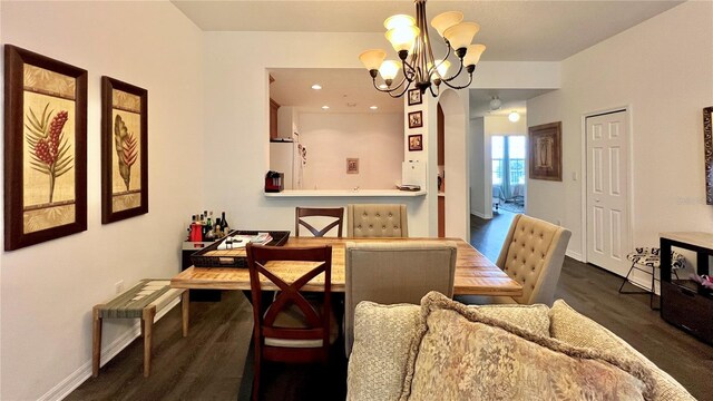 dining space with an inviting chandelier, baseboards, recessed lighting, and dark wood-style floors