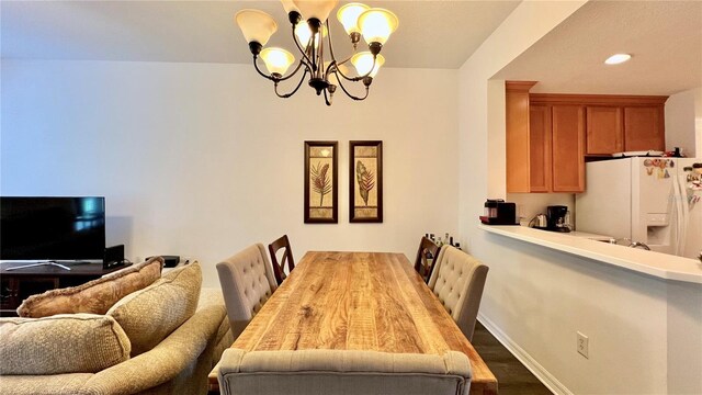 dining space featuring an inviting chandelier, baseboards, and recessed lighting