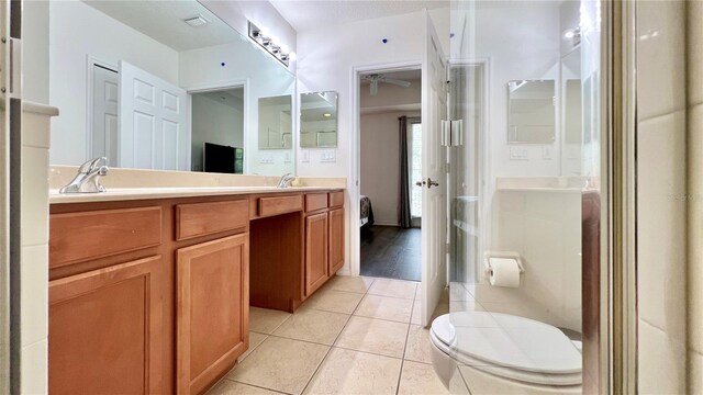 bathroom featuring double vanity, a ceiling fan, tile patterned flooring, a sink, and toilet