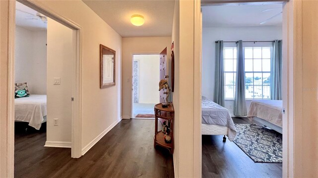 hall with dark wood-type flooring and baseboards