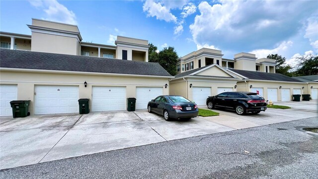 exterior space featuring stucco siding and community garages