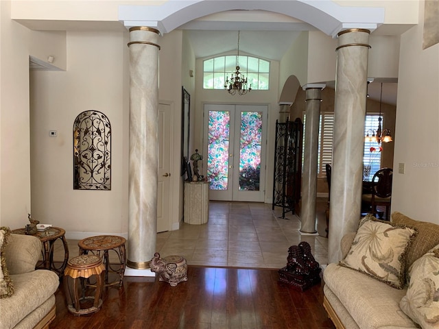 entrance foyer with decorative columns, arched walkways, and an inviting chandelier