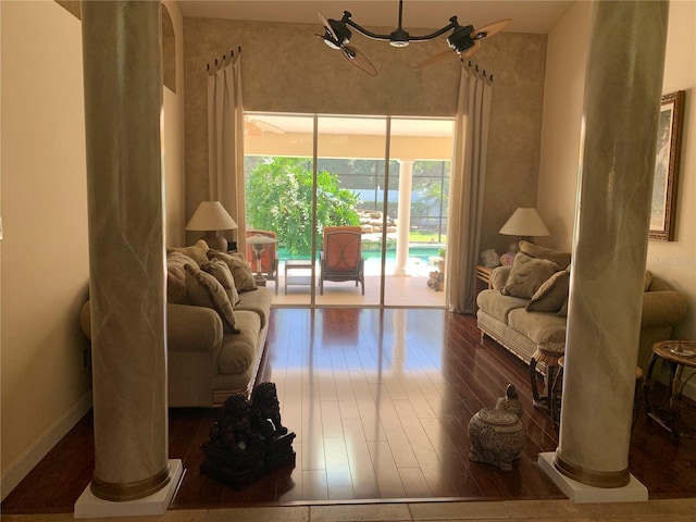 living area featuring wood-type flooring and ornate columns