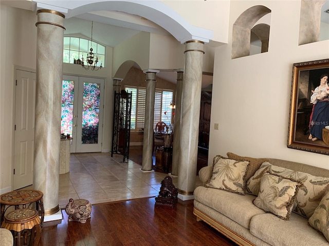entryway featuring a chandelier, decorative columns, arched walkways, and baseboards