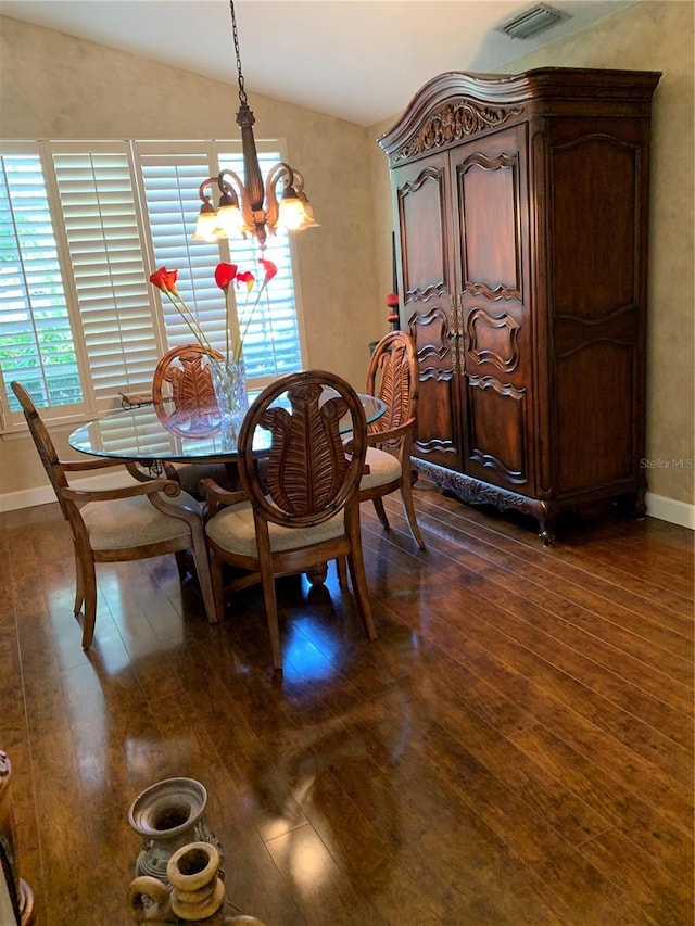 dining room with an inviting chandelier, a healthy amount of sunlight, and dark wood-style floors