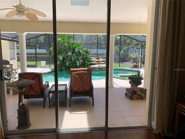doorway featuring ceiling fan, a wealth of natural light, and tile patterned floors