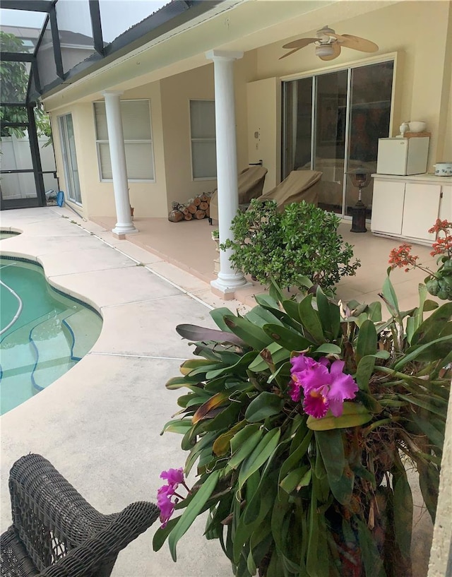pool with a lanai, a ceiling fan, and a patio area