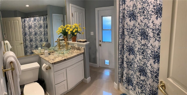bathroom with tile patterned floors, a shower with curtain, toilet, vanity, and baseboards