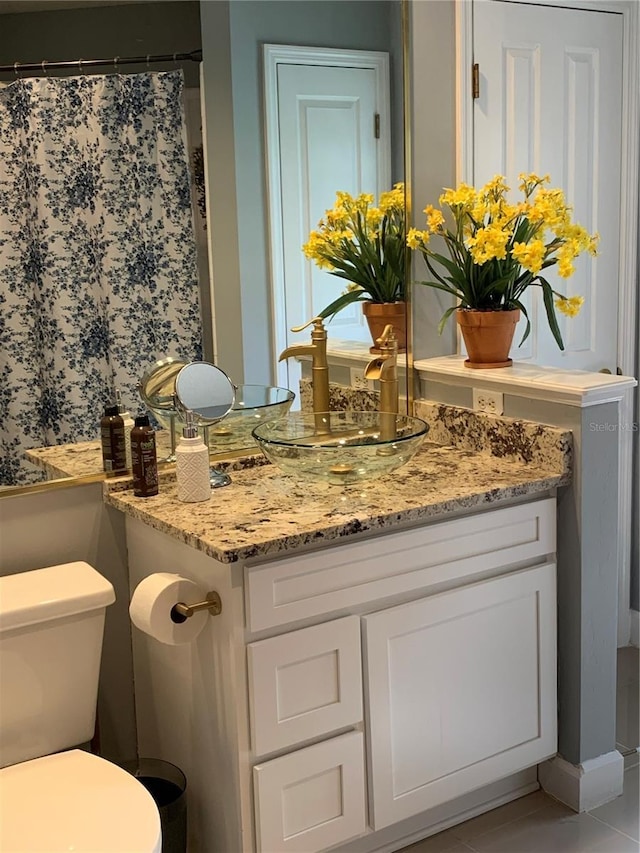 full bathroom featuring toilet, curtained shower, tile patterned flooring, and vanity