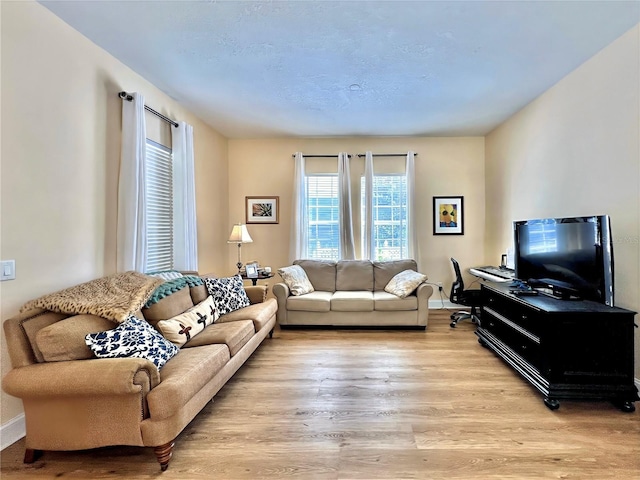 living room featuring light wood finished floors and baseboards