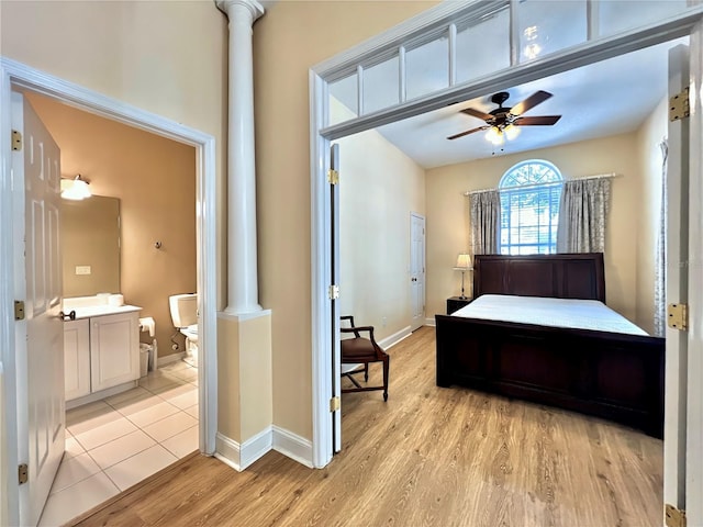bedroom featuring baseboards, ornate columns, a ceiling fan, and light wood-style floors