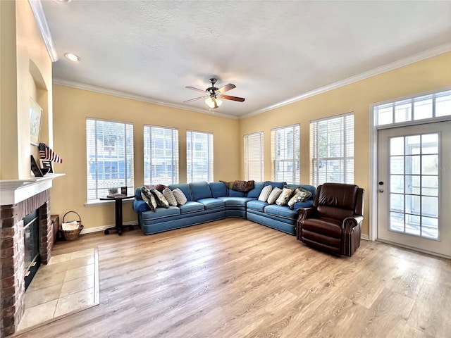 living room featuring ornamental molding, ceiling fan, wood finished floors, and a fireplace