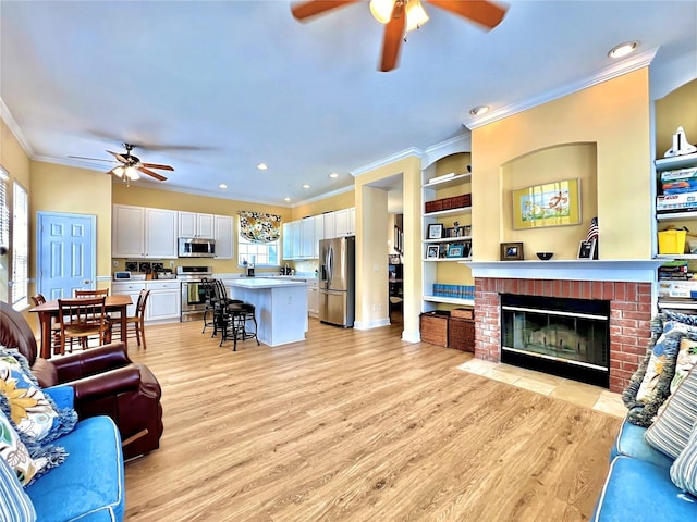 living room with ceiling fan, plenty of natural light, and ornamental molding