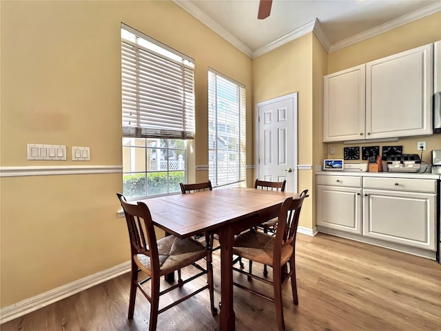 dining room with crown molding, ceiling fan, baseboards, and light wood-style floors