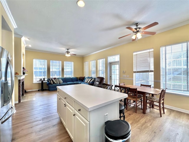 kitchen with a ceiling fan, stainless steel refrigerator with ice dispenser, and a wealth of natural light