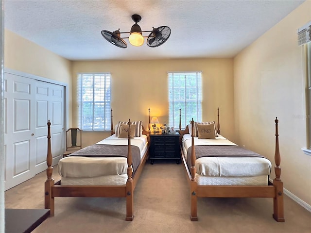 bedroom featuring a closet, a ceiling fan, carpet floors, and a textured ceiling