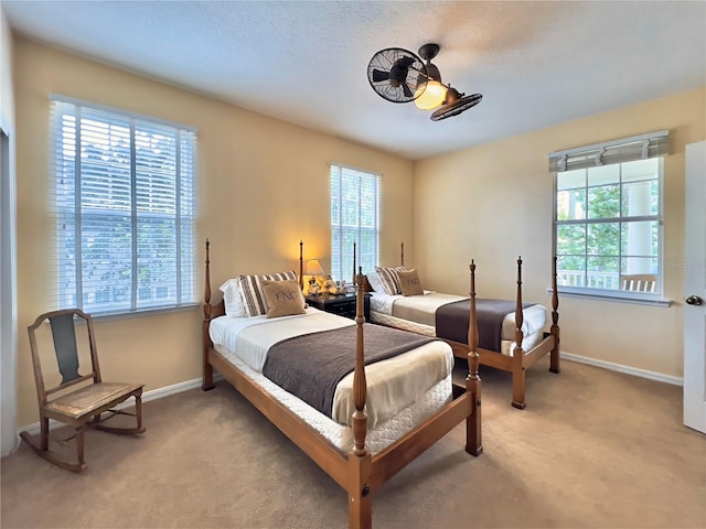 bedroom with light carpet, baseboards, and multiple windows
