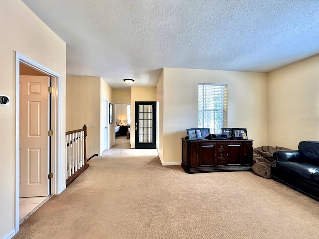 living room with baseboards, light carpet, and a textured ceiling