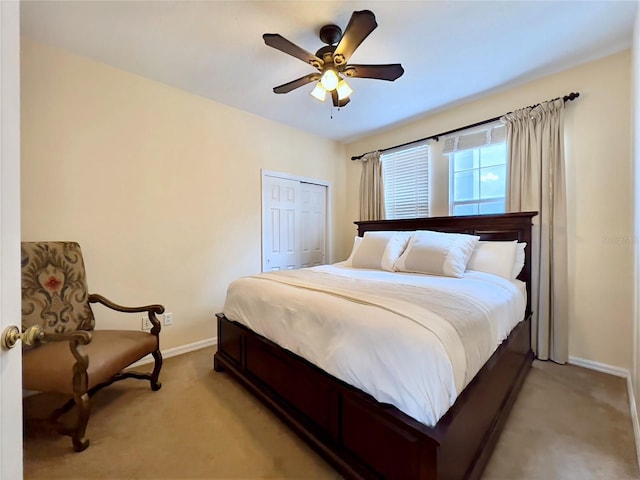 bedroom featuring light colored carpet, a closet, a ceiling fan, and baseboards