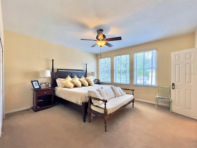 bedroom with baseboards, a ceiling fan, and light colored carpet