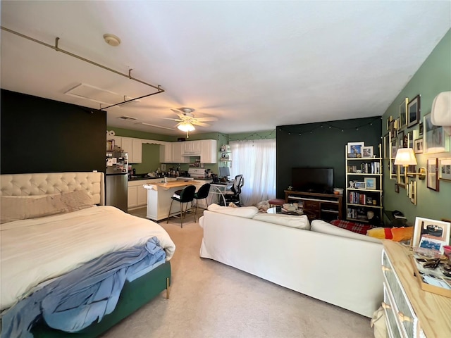 bedroom featuring attic access, a ceiling fan, and freestanding refrigerator