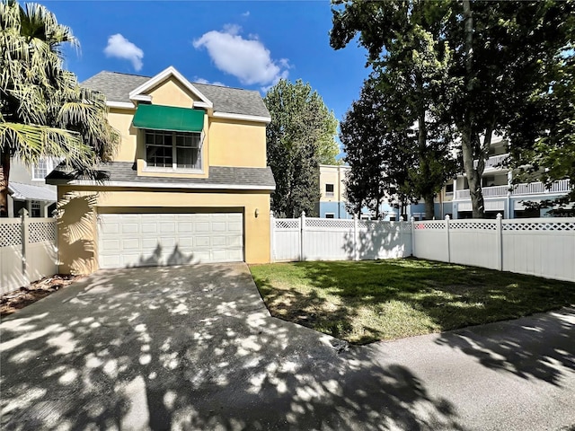 view of side of property with stucco siding, an attached garage, fence, driveway, and a lawn