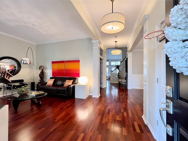 entryway featuring ornamental molding, wood finished floors, and ornate columns