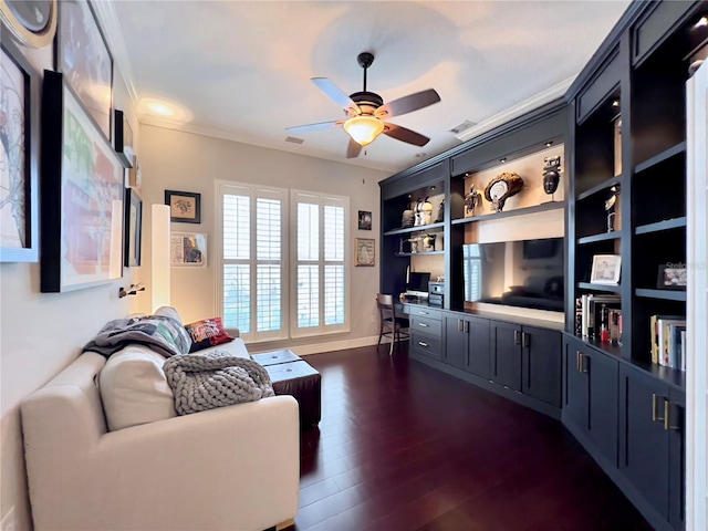 living room featuring dark wood-type flooring, a ceiling fan, crown molding, and baseboards