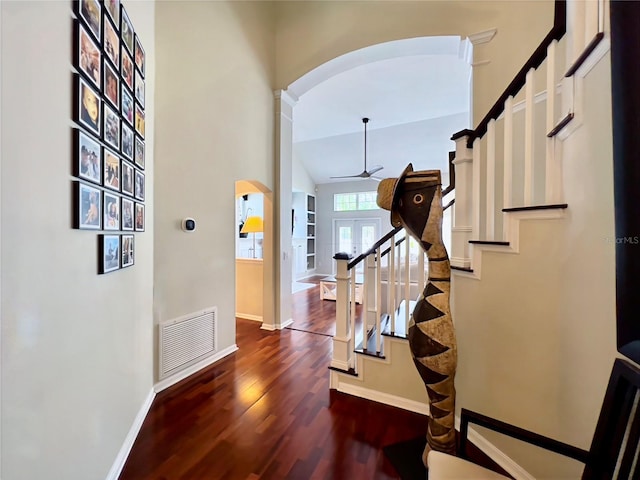 foyer entrance with arched walkways, visible vents, a ceiling fan, and baseboards