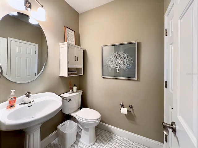 half bath featuring toilet and baseboards