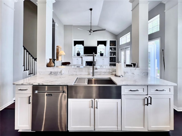kitchen featuring decorative columns, stainless steel dishwasher, ceiling fan, and light stone counters