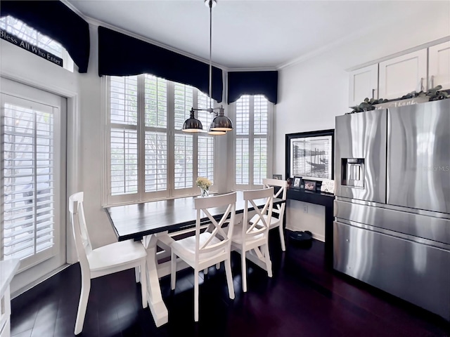 dining area featuring ornamental molding and dark wood finished floors
