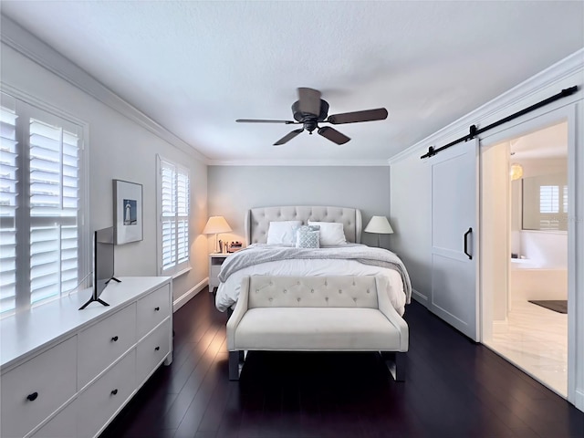bedroom with dark wood-style floors, multiple windows, and a barn door