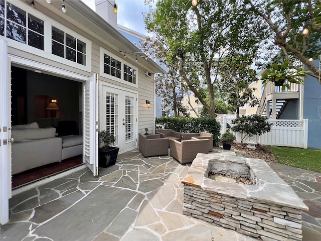 view of patio / terrace with an outdoor hangout area, french doors, and fence