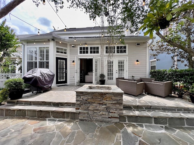 rear view of property featuring an outdoor fire pit, french doors, and a patio area