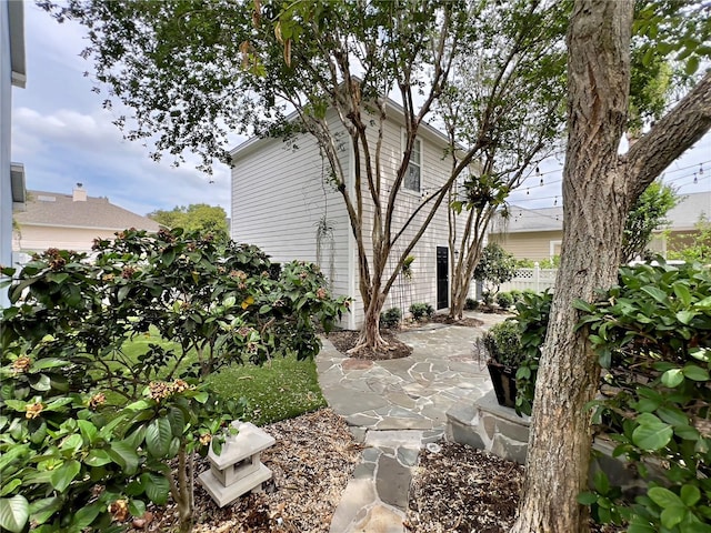 view of side of home with fence and a patio area