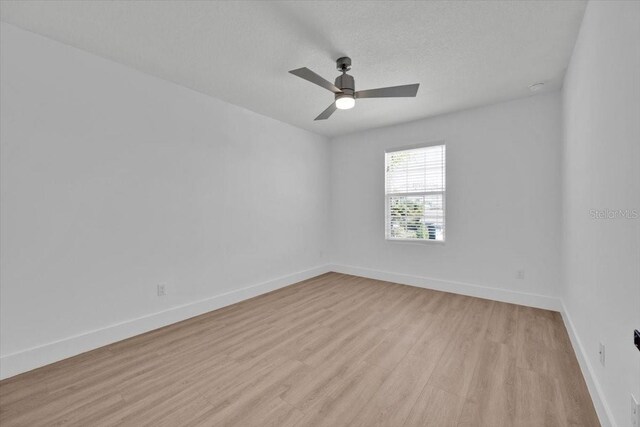 unfurnished room featuring light wood finished floors, a ceiling fan, and baseboards