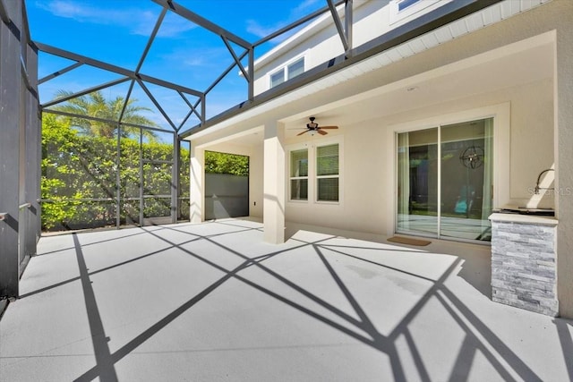 view of patio with ceiling fan and glass enclosure