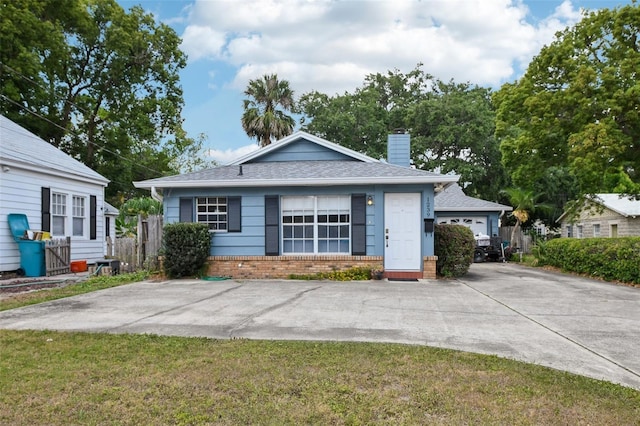 1239 E Ridgewood St, Orlando, FL 32803 - bungalow-style house with fence, a chimney, a front lawn, and brick siding